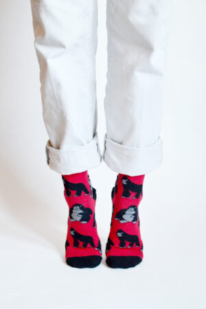 Füsse auf Zehenspitzen mit rot-schwarzen fairtrade Socken mit Gorillamotiv von Barekind